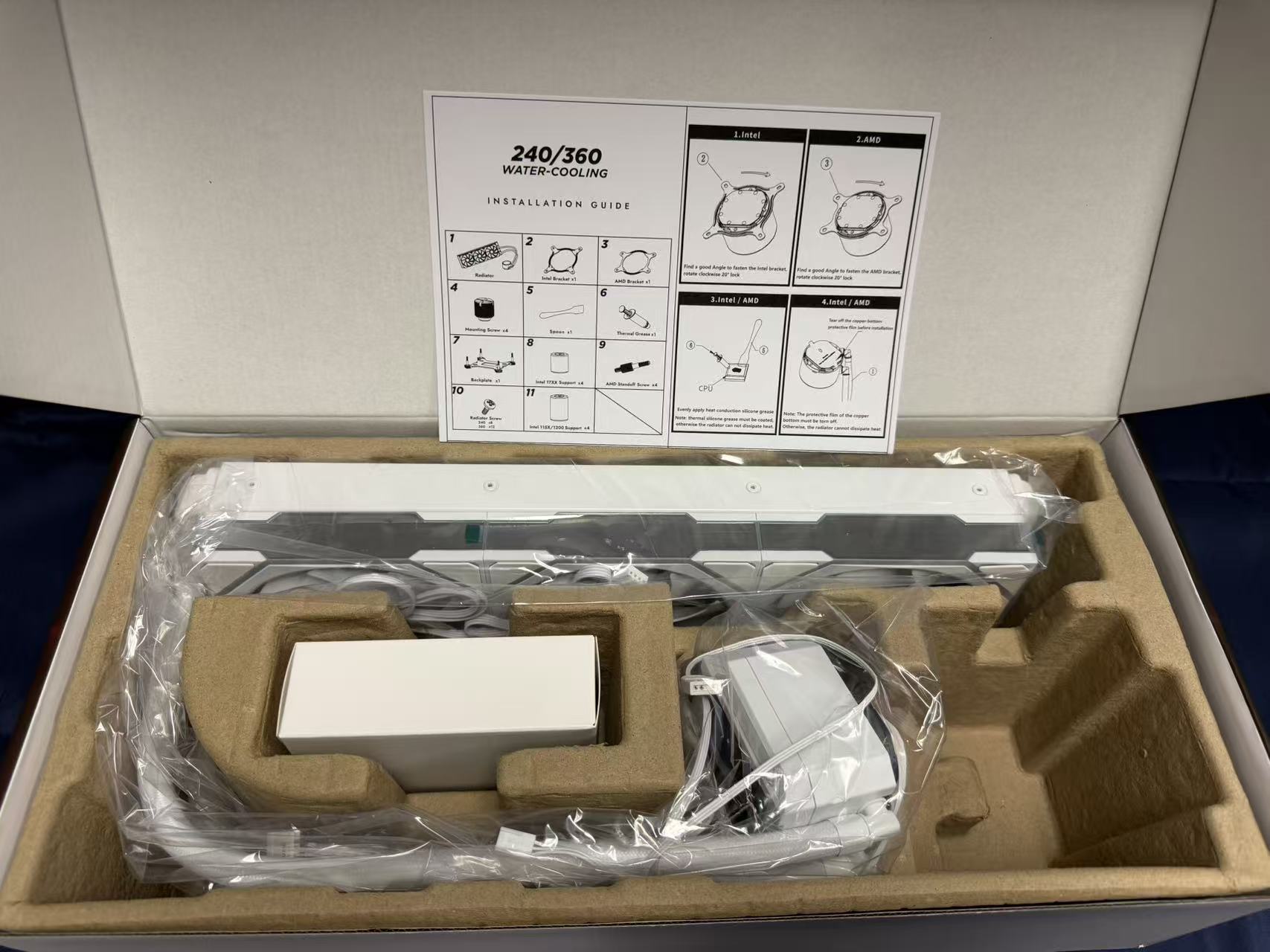 Open HotBell HB3XCF1 white liquid CPU cooler package with radiator, pump display, cables, protective inserts, and installation guide