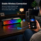 Colorful Bluetooth speaker on a table with a person holding a phone showing music app, in a living room setting.